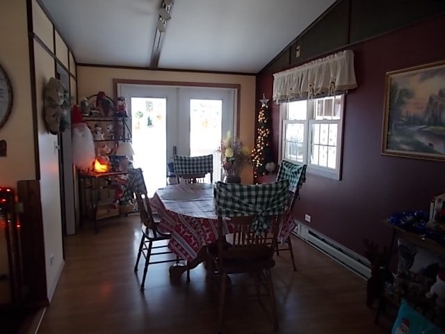 dining space with french doors, dark hardwood / wood-style flooring, vaulted ceiling, and a baseboard heating unit