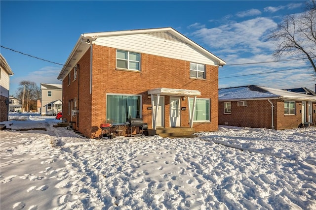 view of snow covered rear of property