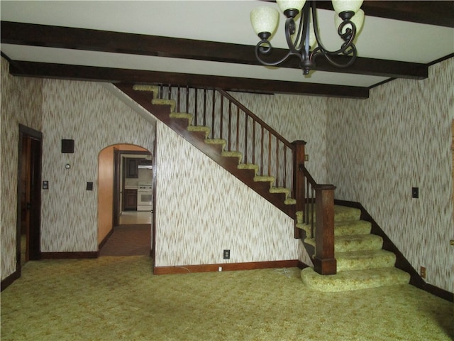 506 W 5th St, Pana, IL 62557 - stairway featuring wallpapered walls, arched walkways, beam ceiling, carpet flooring, and baseboards