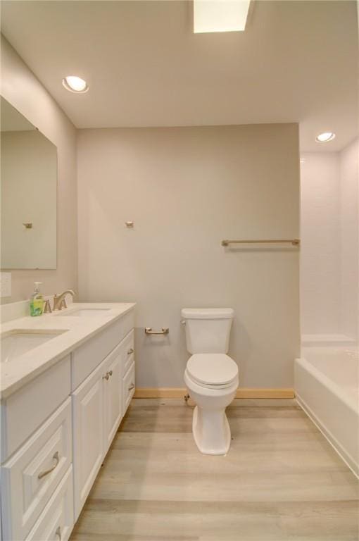 bathroom featuring toilet, hardwood / wood-style floors, and vanity