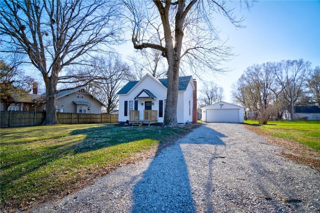 view of front of home featuring a front yard, a garage, and an outdoor structure