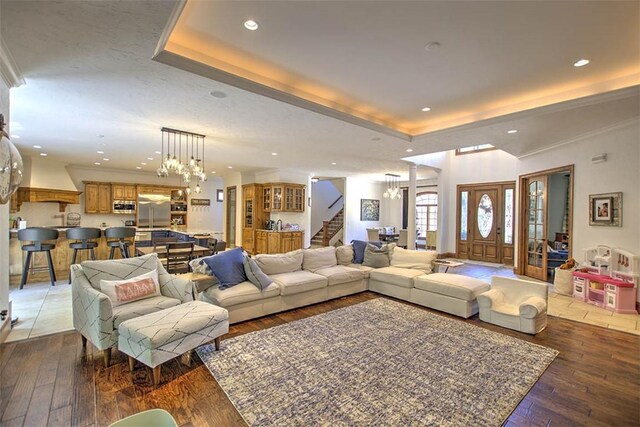 2125 Reserve Way, Decatur, IL 62521 - living room featuring a chandelier, stairway, a raised ceiling, light wood-style floors, and recessed lighting