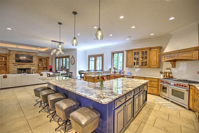 2125 Reserve Way, Decatur, IL 62521 - kitchen featuring double oven range, ornamental molding, brown cabinetry, a breakfast bar, and light tile patterned floors