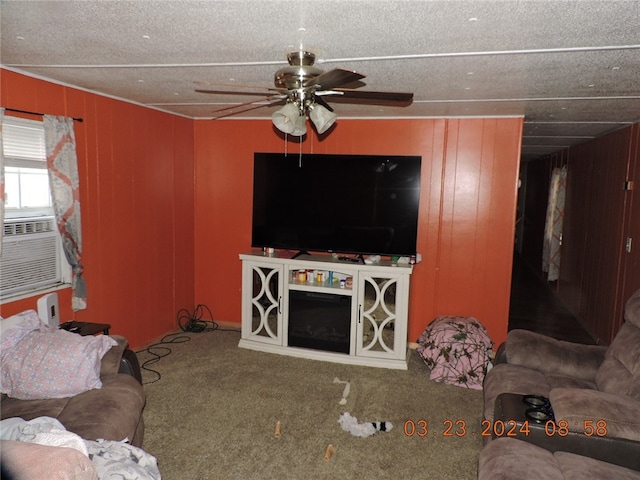 living room with carpet flooring, ceiling fan, cooling unit, and wood walls