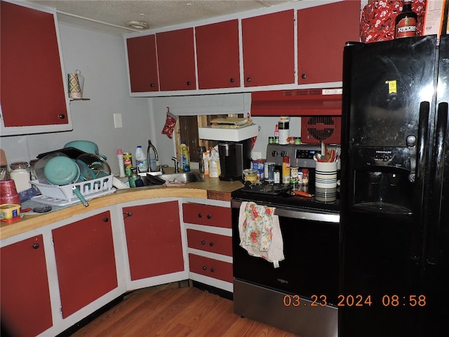 kitchen with stainless steel electric range oven, sink, wood-type flooring, a textured ceiling, and black fridge with ice dispenser