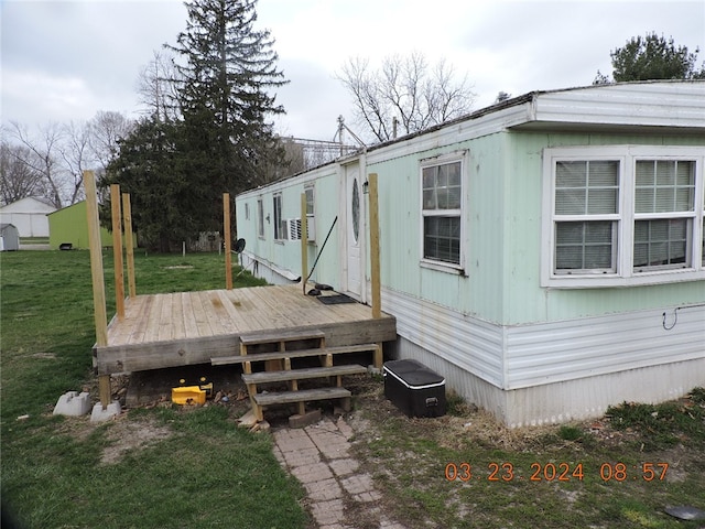 view of side of home with a wooden deck and a yard