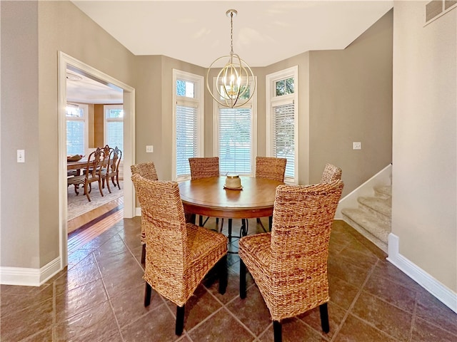 tiled dining space with an inviting chandelier