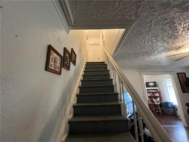 stairs featuring a textured wall and ornamental molding