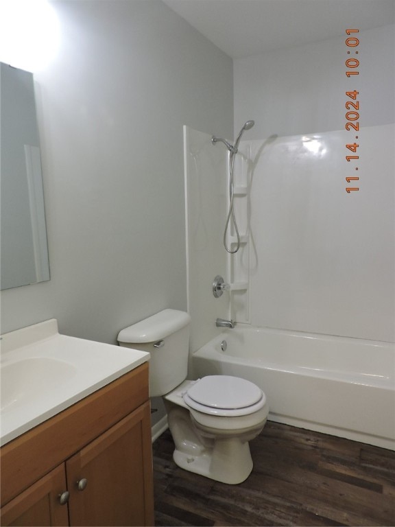 full bathroom with vanity, toilet, wood-type flooring, and bathtub / shower combination