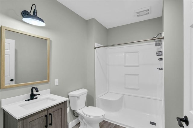 bathroom with vanity, hardwood / wood-style floors, toilet, and walk in shower