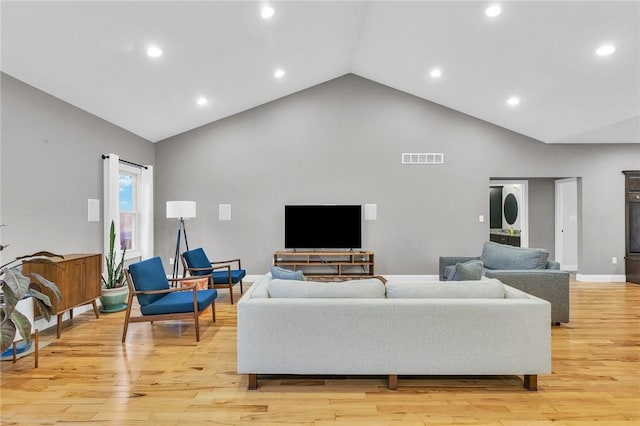 living room featuring light hardwood / wood-style flooring and high vaulted ceiling