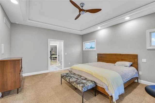 carpeted bedroom with ceiling fan and a tray ceiling