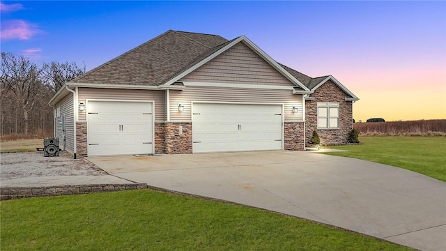 view of front of property with a garage and a lawn