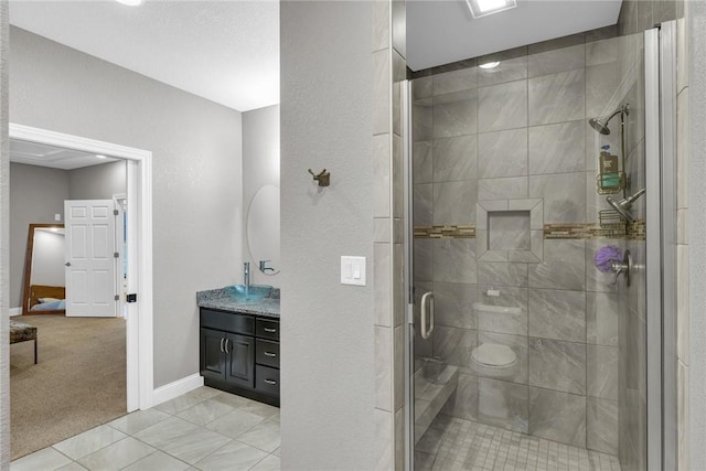 bathroom featuring vanity, tile patterned floors, a shower with door, and toilet