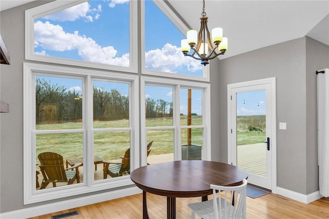 dining area with light hardwood / wood-style floors and a notable chandelier