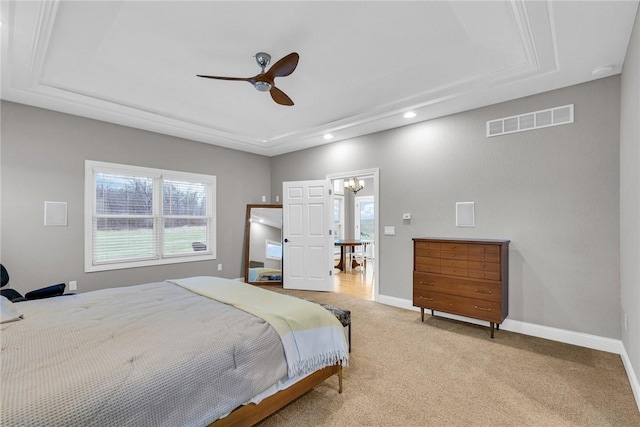 bedroom featuring ceiling fan, a raised ceiling, and light carpet