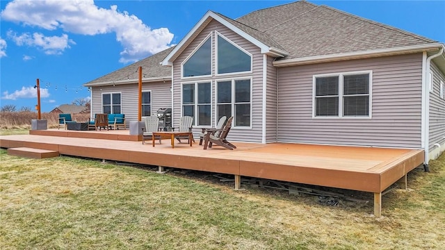 rear view of house featuring a wooden deck and a yard