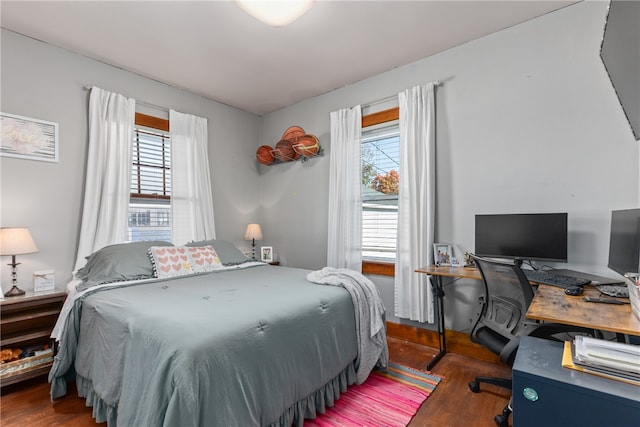 bedroom with multiple windows and dark wood-type flooring