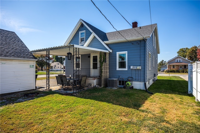 rear view of property with a patio, central air condition unit, and a lawn