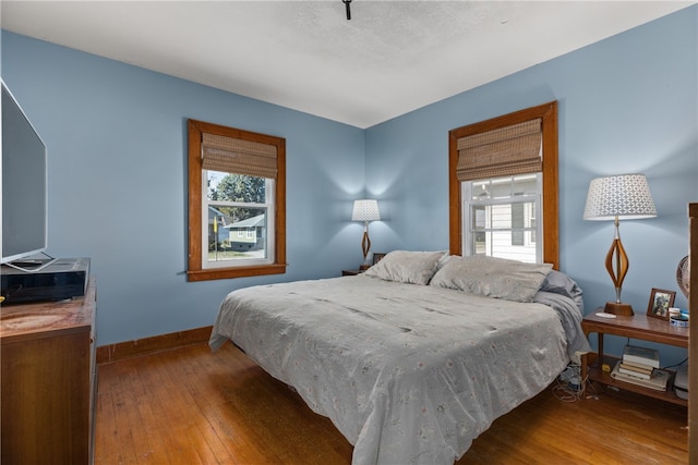 bedroom with wood-type flooring and multiple windows