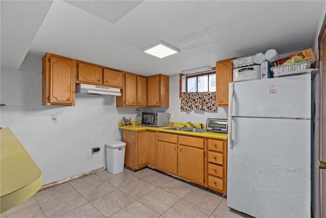 kitchen featuring sink, white fridge, and light tile patterned flooring