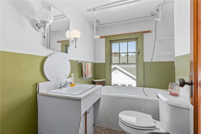 bathroom featuring vanity, toilet, tile walls, and tiled bath