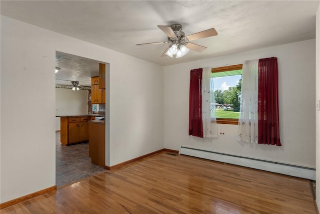 300 Olive St, Watson, IL 62473 - empty room with baseboard heating, a ceiling fan, and wood finished floors