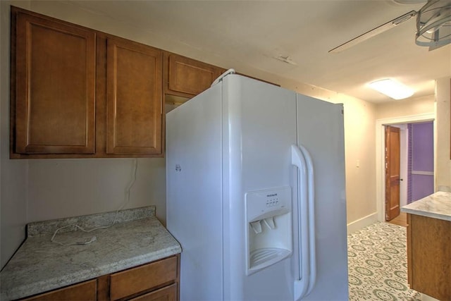 1591 Decatur St, Decatur, IL 62522 - kitchen featuring white refrigerator with ice dispenser, light countertops, and brown cabinetry