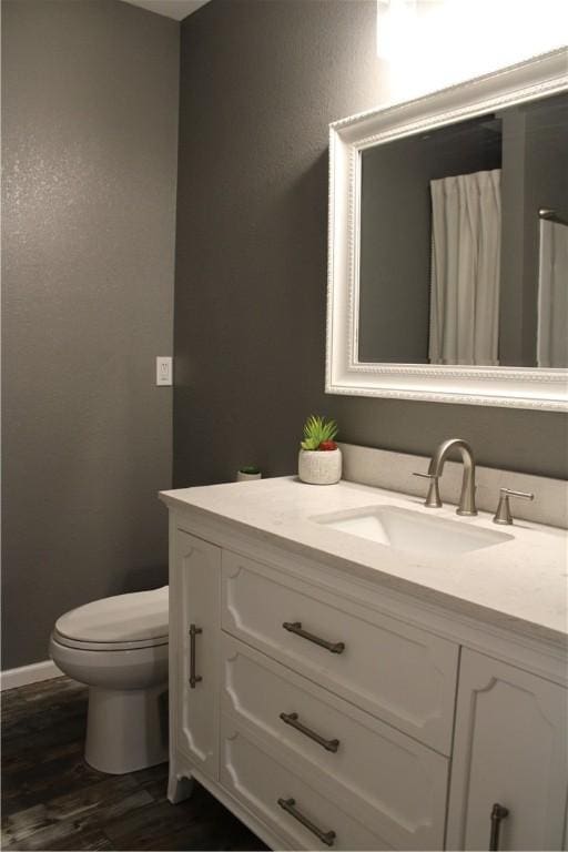 bathroom featuring vanity, toilet, and wood finished floors