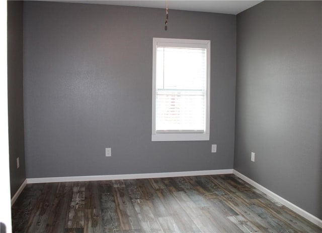 unfurnished room with baseboards and wood finished floors