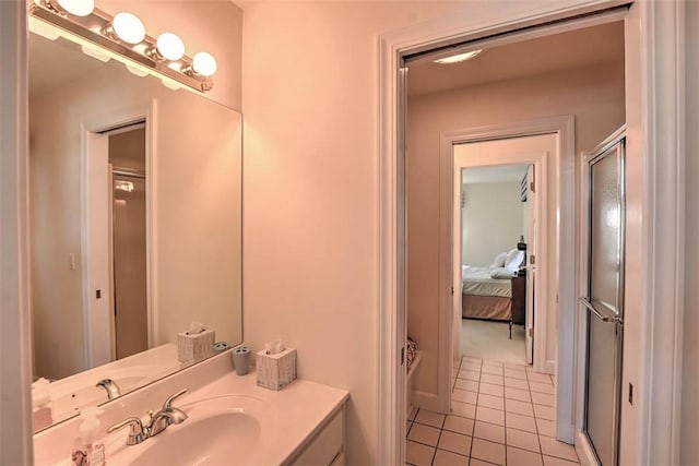 bathroom with tile patterned flooring, connected bathroom, vanity, and a shower with door