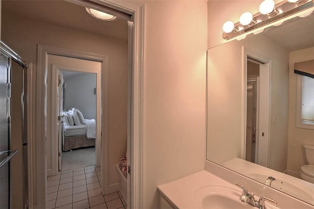 ensuite bathroom with vanity, tile patterned floors, toilet, and ensuite bath