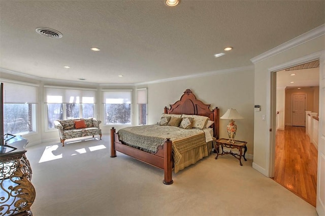 bedroom with a textured ceiling, light carpet, visible vents, and ornamental molding