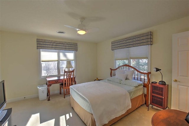 bedroom with visible vents, light carpet, baseboards, and ceiling fan