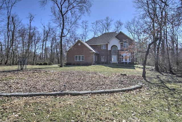 traditional-style house with brick siding and a front lawn