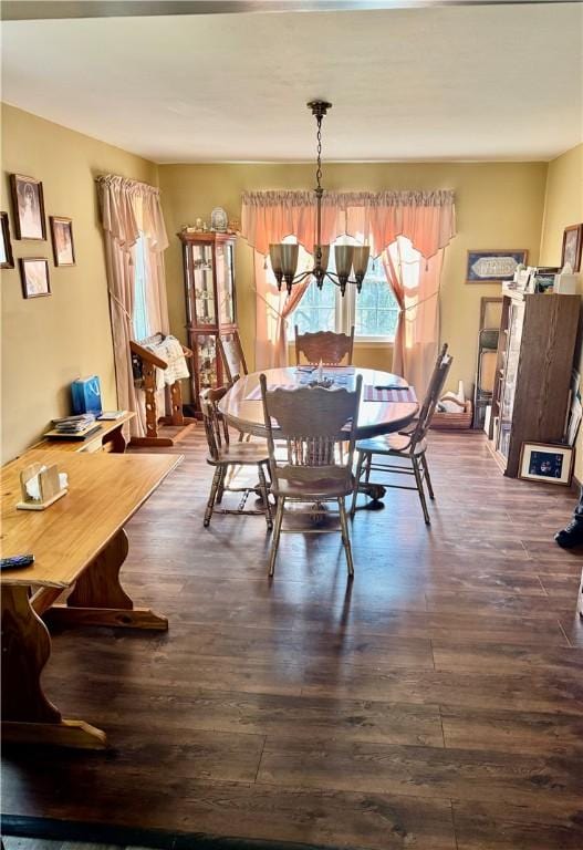 dining area featuring a notable chandelier and dark wood-style floors