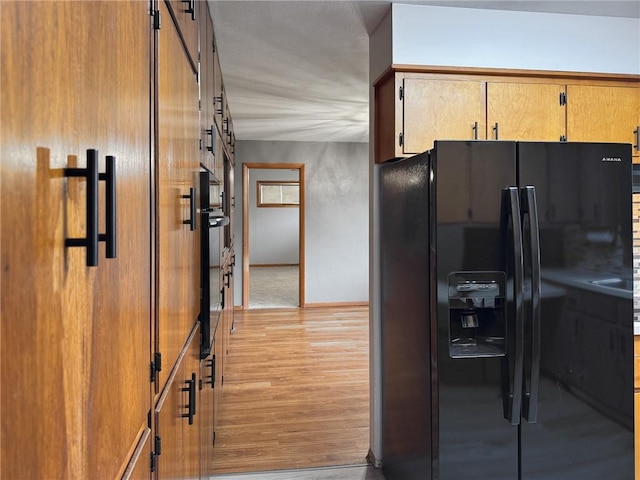 1511 E Fayette Ave, Teutopolis, IL 62467 - kitchen featuring black appliances, light wood-style floors, and brown cabinets