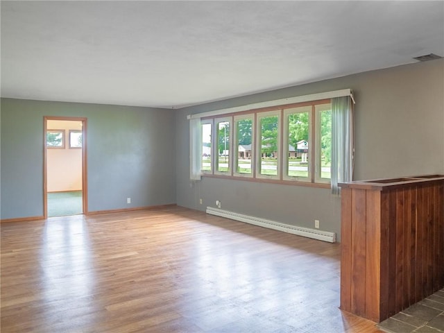 1511 E Fayette Ave, Teutopolis, IL 62467 - unfurnished room featuring a baseboard heating unit and wood finished floors