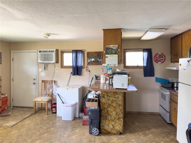 1511 E Fayette Ave, Teutopolis, IL 62467 - kitchen featuring white appliances, under cabinet range hood, an AC wall unit, and a textured ceiling