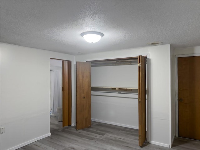 1511 E Fayette Ave, Teutopolis, IL 62467 - unfurnished bedroom with a textured ceiling, wood finished floors, and a closet