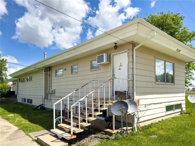 1511 E Fayette Ave, Teutopolis, IL 62467 - back of house with a wall unit AC and a lawn