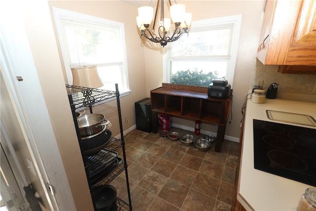 interior space with hanging light fixtures, decorative backsplash, plenty of natural light, and a notable chandelier