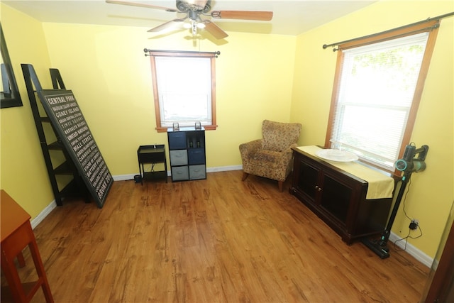 sitting room with light wood-type flooring and ceiling fan