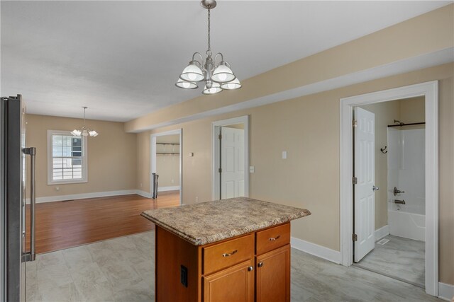 kitchen with a chandelier, pendant lighting, light hardwood / wood-style flooring, and a kitchen island