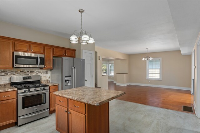 kitchen with stainless steel appliances, an inviting chandelier, and a wealth of natural light