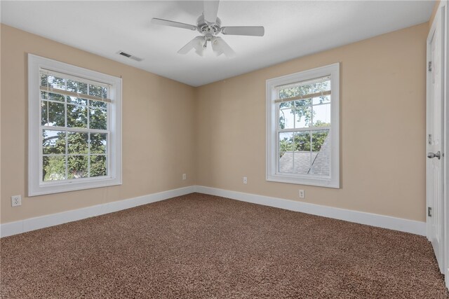 carpeted spare room with a wealth of natural light and ceiling fan