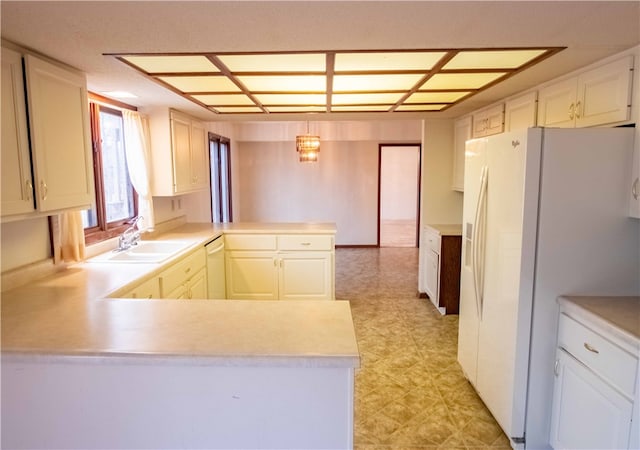 kitchen with white cabinets, white appliances, kitchen peninsula, and sink