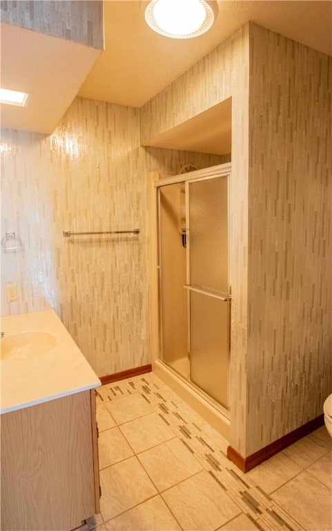 bathroom with tile patterned flooring, vanity, toilet, and an enclosed shower