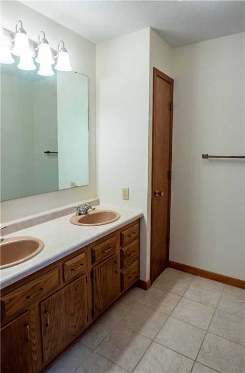 bathroom with tile patterned floors, vanity, and a textured ceiling