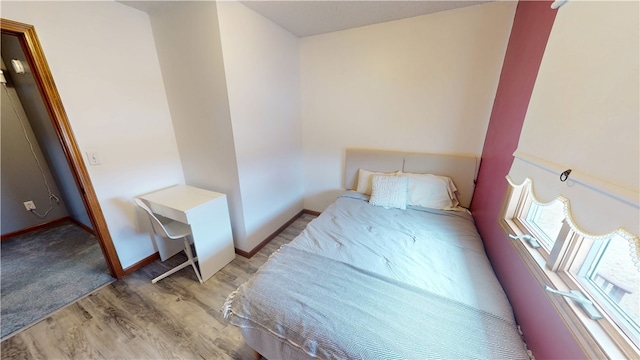 bedroom with light wood-type flooring and baseboards